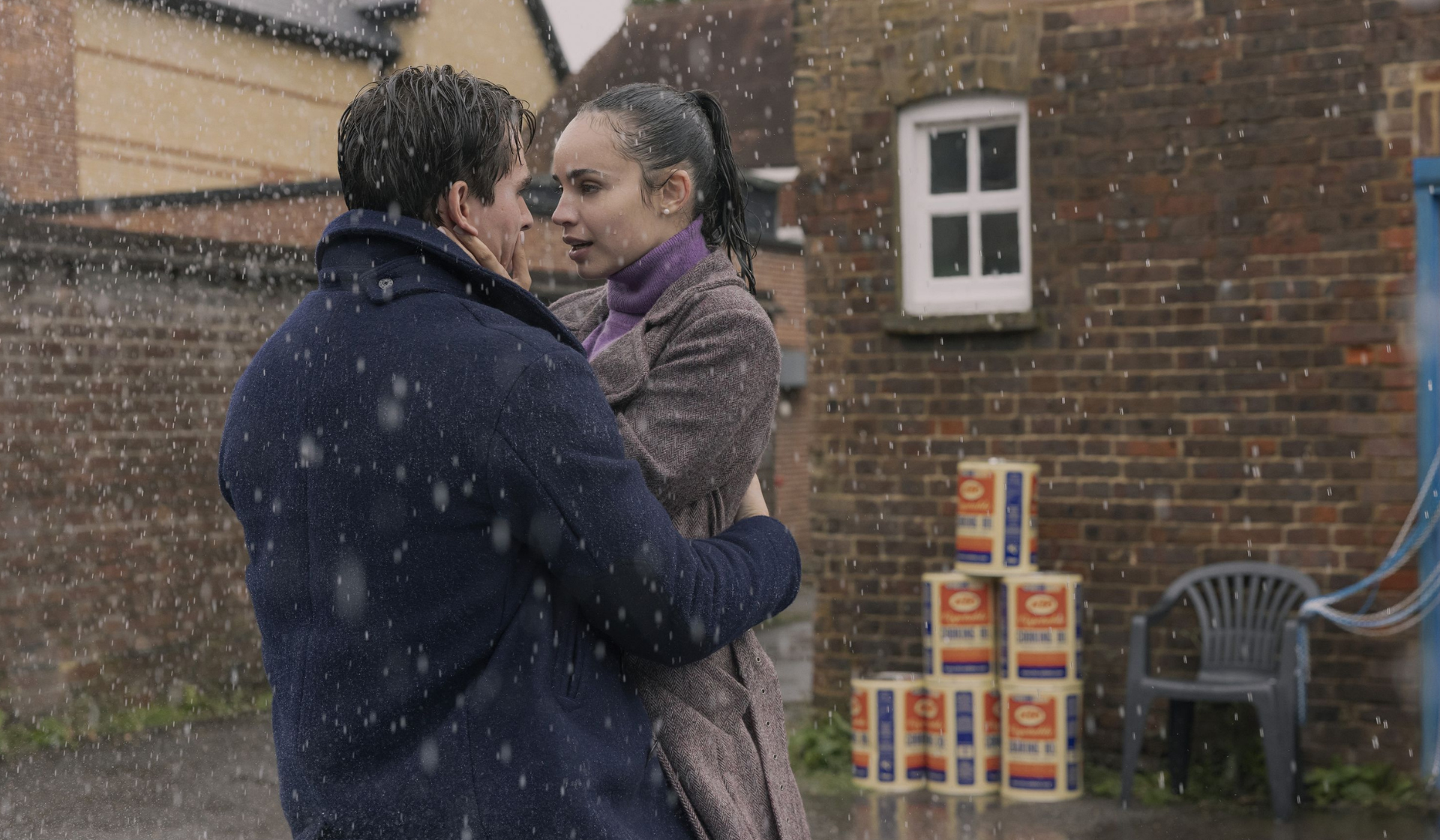 Scene from Netflix's My Oxford Year starring Sofia Carson and Corey Mylchreest embracing in the rain.