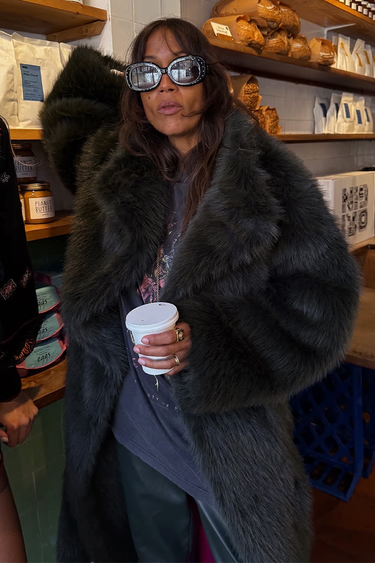 model wearing long green faux fur coat 